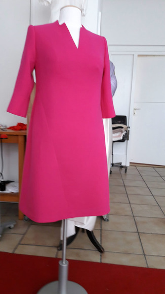 Kleid - 
	magentafarbender
	Wollstrukturgeorgett
	mit dekorativ verlegten
	Teilungsnähten in Vorder-
	und Rückenteil

 - Modeatelier meins